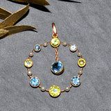 Yellow gold round pendant set with five aquamarine, four peridot and eight pearls.