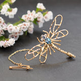Vintage yellow gold dragonfly brooch with a blue topaz set to the centre. With diamond eyes. 