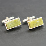 A pair of silver rectangular cuff links with green marble set to the fronts. Swivel backs.