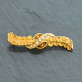 Antique yellow gold fancy brooch set with seven seed pearls.