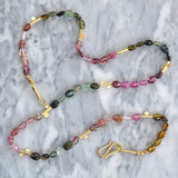 Single row gemstone necklace including pink tourmaline, green tourmaline and brown tourmaline with 18ct gold sections and hook clasp.