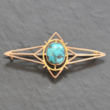 Rose gold brooch with a single oval matrix turquoise set to the centre in a rub over setting. 