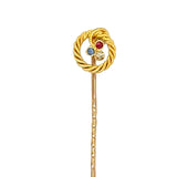 Gold tie pin with multicolored gemstones on a white background