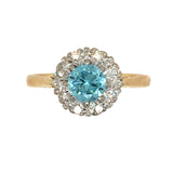 An 18ct yellow and white gold ring with a round blue zircon stone surrounded by eight diamonds set in a gold ring.