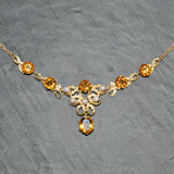 Fancy yellow gold necklace set with six citrine and five pearls.