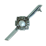 A silver bar brooch with a central pearl and marcasite stones set in a square pattern, featuring a safety catch.