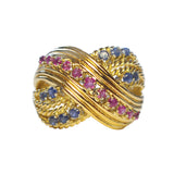An 18ct gold ruby and sapphire cocktail ring with a twist design, featuring multiple rubies and sapphires.