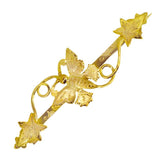 A 9ct gold bar brooch with a butterfly design in the centre surrounded by ivy leaves, with twine linking the leaves to the butterfly.