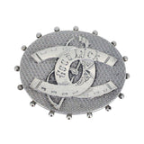 A Victorian silver oval brooch with two horse shoes and a whip to the front, engraved 'GOOD LUCK'.