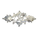 Antique silver brooch with a central bird design and surrounding floral patterns.