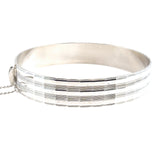 Vintage silver bangle with a diamond cut pattern.